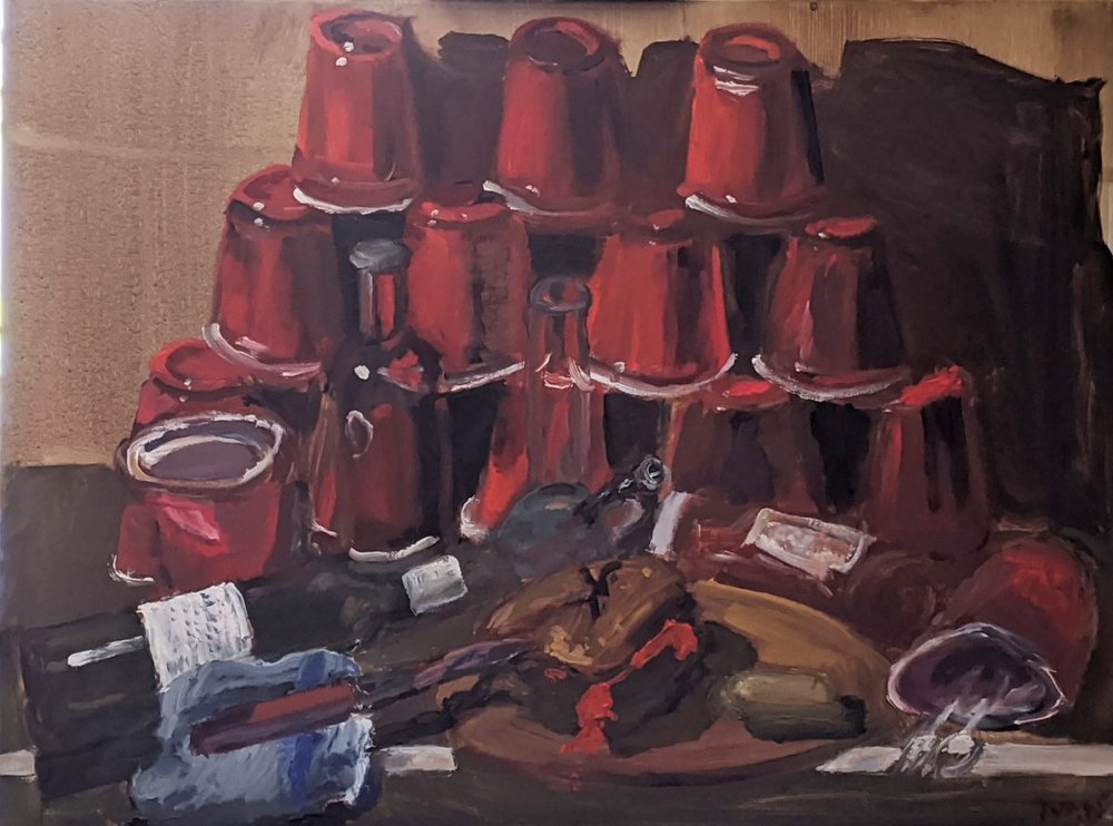 Still life in reds: stacked plastic cups, bottles and the debris of a party on a dark ground